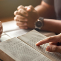 young man reading bible with friends who are praying to God Join the cell group at the church. A small group of Christians or concepts in a church at a church.